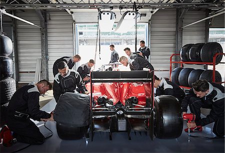 simsearch:6113-06753251,k - Pit crew working on formula one race car in repair garage Foto de stock - Sin royalties Premium, Código: 6113-08927874