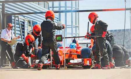 simsearch:6113-08927792,k - Pit crew replacing tires on formula one race car in pit lane Stock Photo - Premium Royalty-Free, Code: 6113-08927882