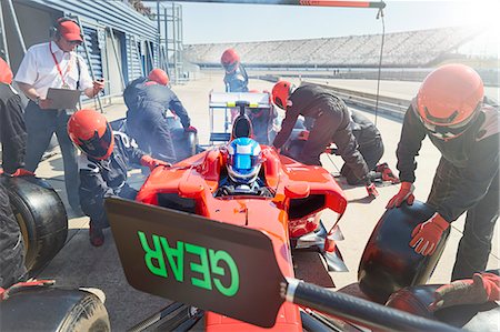 simsearch:6113-08927792,k - Pit crew replacing tires on formula one race car in pit lane Stock Photo - Premium Royalty-Free, Code: 6113-08927826