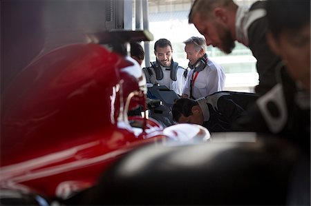Manager and formula one race car driver talking in repair garage Stock Photo - Premium Royalty-Free, Code: 6113-08927945