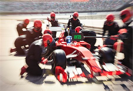 Pit crew replacing tires on formula one race car in pit lane Foto de stock - Royalty Free Premium, Número: 6113-08927955