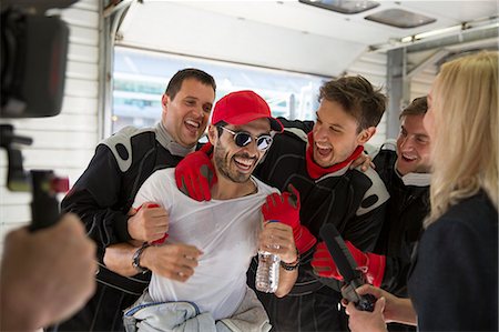 Formula one driver and team celebrating victory in repair garage Stock Photo - Premium Royalty-Free, Code: 6113-08927958