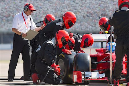 pit - Manager with stopwatch timing pit crew replacing formula one race car tire in pit lane Stock Photo - Premium Royalty-Free, Code: 6113-08927905