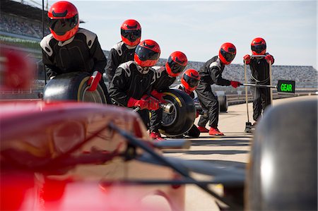 poised - Pit crew with tires ready for nearing formula one race car in pit lane Stock Photo - Premium Royalty-Free, Code: 6113-08927914