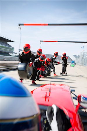 extreme sports team - Pit crew with tires ready for nearing formula one race car in pit lane Stock Photo - Premium Royalty-Free, Code: 6113-08927918