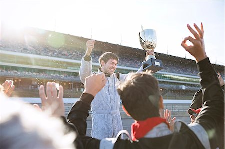 simsearch:614-06442276,k - Formula one racing team cheering for driver with trophy, celebrating victory on sports track Foto de stock - Sin royalties Premium, Código: 6113-08927922