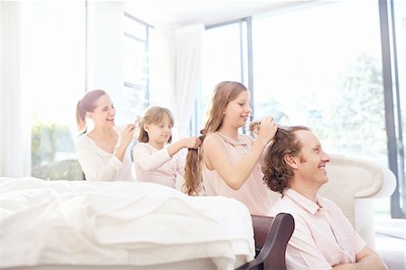 Family fixing each other's hair in a row Stock Photo - Premium Royalty-Free, Code: 6113-08928064