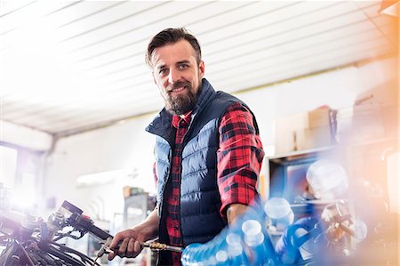 simsearch:6113-08805791,k - Portrait confident male motorcycle mechanic working in workshop Foto de stock - Sin royalties Premium, Código: 6113-08928012