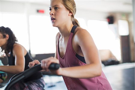 simsearch:649-03418201,k - Determined young woman using elliptical bike in gym Photographie de stock - Premium Libres de Droits, Code: 6113-09058278