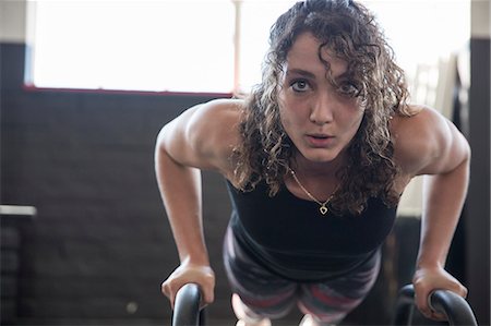 simsearch:6113-08536097,k - Portrait determined young woman doing push-ups with equipment in gym Stock Photo - Premium Royalty-Free, Code: 6113-09058285