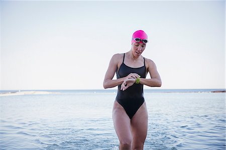 sport extrême - Female open water swimmer checking time on smart watch in ocean surf Photographie de stock - Premium Libres de Droits, Code: 6113-09058343