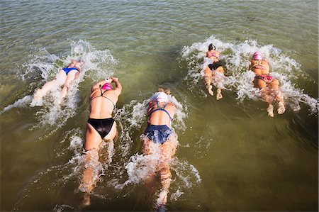 simsearch:649-09205713,k - Overhead view female open water swimmers swimming in sunny ocean Photographie de stock - Premium Libres de Droits, Code: 6113-09058361