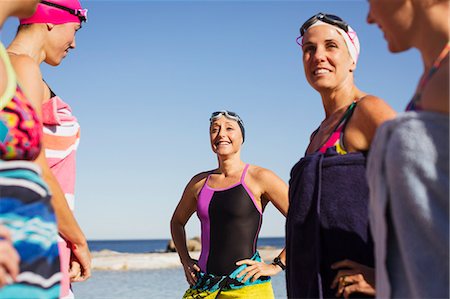 swimming - Smiling female open water swimmers wrapped din towels on sunny beach Stock Photo - Premium Royalty-Free, Code: 6113-09058379