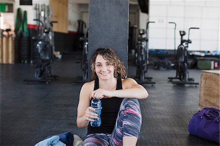 simsearch:6113-08536110,k - Portrait smiling, confident young woman drinking water and resting post workout in gym Stock Photo - Premium Royalty-Free, Code: 6113-09058307