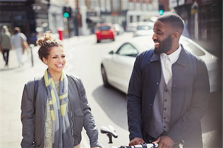 simsearch:6113-06625578,k - Smiling couple commuting with bicycle on sunny urban street Stockbilder - Premium RF Lizenzfrei, Bildnummer: 6113-09058459