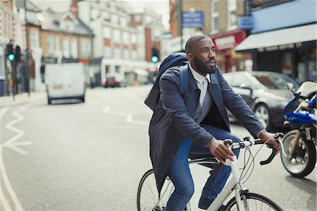 simsearch:614-06536822,k - Businessman commuting, riding bicycle on urban street Stock Photo - Premium Royalty-Free, Code: 6113-09058462