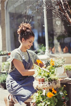 storefronts with flowers - Female florist arranging display at sunny flower shop storefront Stock Photo - Premium Royalty-Free, Code: 6113-09058472