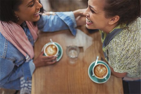 simsearch:6124-09239356,k - Young affectionate female friends drinking coffee and laughing in cafe Photographie de stock - Premium Libres de Droits, Code: 6113-09058477