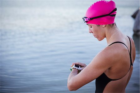 simsearch:6113-09058409,k - Female open water swimmer checking smart watch at ocean Photographie de stock - Premium Libres de Droits, Code: 6113-09058415