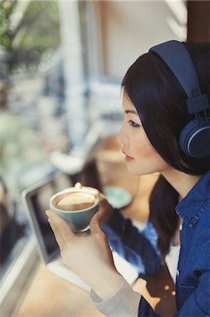 simsearch:6113-09220496,k - Pensive young woman drinking coffee, listening to music with headphones at cafe window Stockbilder - Premium RF Lizenzfrei, Bildnummer: 6113-09058424