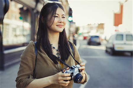 simsearch:6113-07542500,k - Smiling young female tourist photographing with camera on urban street Stockbilder - Premium RF Lizenzfrei, Bildnummer: 6113-09058439