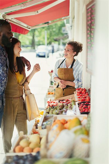 Female worker helping young couple shopping for fruit at market storefront Foto de stock - Sin royalties Premium, Código de la imagen: 6113-09058555