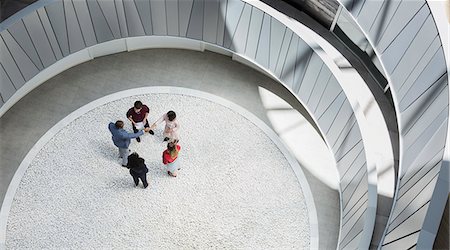 View from above business people handshaking in round modern office atrium courtyard Photographie de stock - Premium Libres de Droits, Code: 6113-09058680