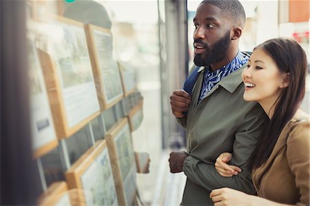 printout - Young couple browsing real estate listings at storefront Stock Photo - Premium Royalty-Free, Code: 6113-09058627