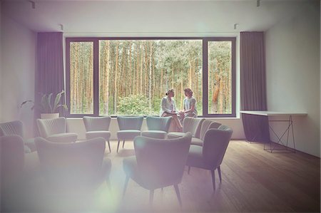 Women talking at window in group therapy room Photographie de stock - Premium Libres de Droits, Code: 6113-09058762