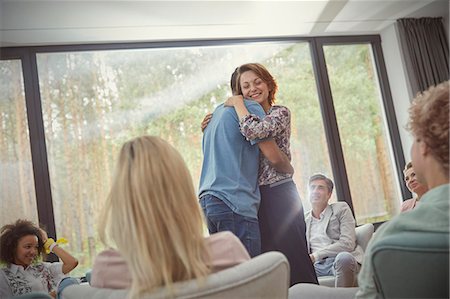 simsearch:6113-09058760,k - Man and woman hugging in group therapy session Stock Photo - Premium Royalty-Free, Code: 6113-09058783