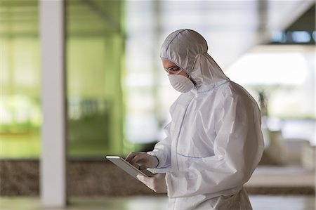 simsearch:6113-07808468,k - Scientist in clean suit using digital tablet Foto de stock - Sin royalties Premium, Código: 6113-09058888