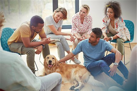 People petting dog in group therapy session Stock Photo - Premium Royalty-Free, Code: 6113-09058802