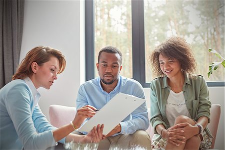 Female therapist with clipboard talking to couple in couples therapy session Foto de stock - Sin royalties Premium, Código: 6113-09058819