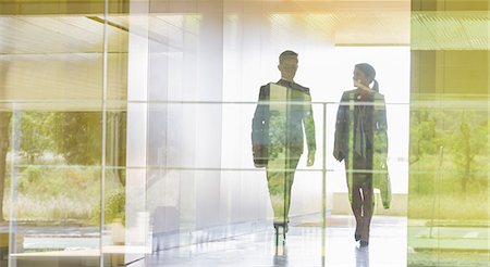 simsearch:6113-09058929,k - Silhouette businessman and businesswoman walking in modern office corridor Foto de stock - Sin royalties Premium, Código: 6113-09058903