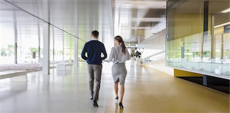 simsearch:6113-09058702,k - Businessman and businesswoman walking in modern office corridor Stock Photo - Premium Royalty-Free, Code: 6113-09058912