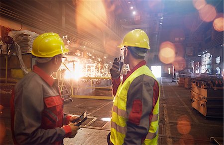 factory flare - Steelworkers with walkie-talkie watching welding in steel mill Stock Photo - Premium Royalty-Free, Code: 6113-09059017