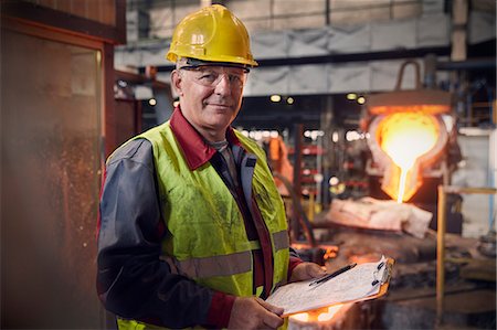 Portrait confident steelworker supervisor with clipboard in steel mill Stock Photo - Premium Royalty-Free, Code: 6113-09059022
