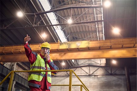 safety worker open arm - Steelworker talking, using walkie-talkie on platform in steel mill Stock Photo - Premium Royalty-Free, Code: 6113-09059026