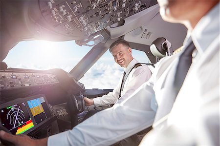 Portrait smiling, confident pilot in airplane cockpit Fotografie stock - Premium Royalty-Free, Codice: 6113-09059147