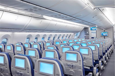 simsearch:614-06623381,k - Rows of seats with entertainment screens on airplane Foto de stock - Sin royalties Premium, Código: 6113-09059149