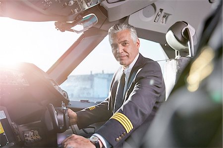 Portrait confident male pilot in airplane cockpit Fotografie stock - Premium Royalty-Free, Codice: 6113-09059157