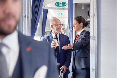 simsearch:6113-09059160,k - Flight attendant helping businessman with digital boarding pass on airplane Photographie de stock - Premium Libres de Droits, Code: 6113-09059180
