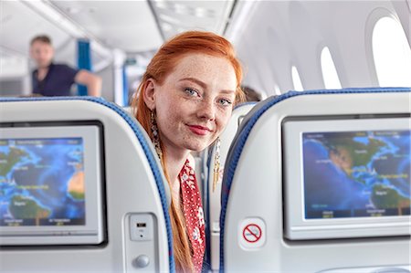 simsearch:6113-09059149,k - Portrait smiling young woman with red hair and freckles on airplane Foto de stock - Royalty Free Premium, Número: 6113-09059194