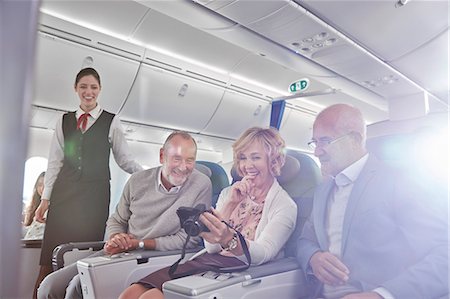 passenger airplane - Friends looking at photos on digital camera on airplane Stock Photo - Premium Royalty-Free, Code: 6113-09059108