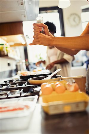simsearch:614-02049325,k - Woman cracking fresh pepper on eggs cooking on stove in kitchen Foto de stock - Sin royalties Premium, Código: 6113-09059244