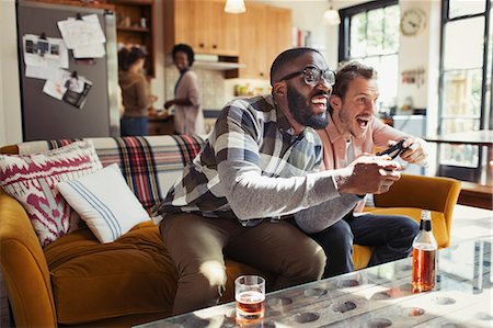 simsearch:6113-09131576,k - Male friends drinking beer and playing video game in living room Stock Photo - Premium Royalty-Free, Code: 6113-09059250