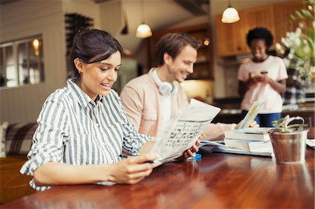 simsearch:6113-09059369,k - Woman reading newspaper at dining table Foto de stock - Sin royalties Premium, Código: 6113-09059264