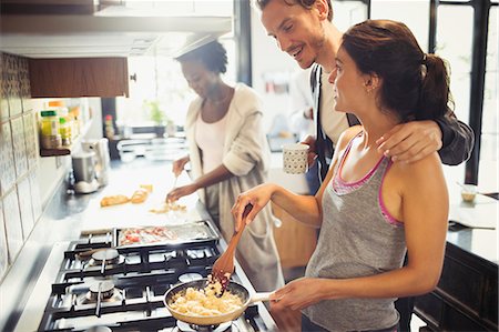 simsearch:6113-09059302,k - Young couple cooking scrambled eggs on stove in kitchen Foto de stock - Sin royalties Premium, Código: 6113-09059283