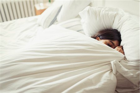 sleeping on bed - Tired young woman sleeping in bed Stock Photo - Premium Royalty-Free, Code: 6113-09059224