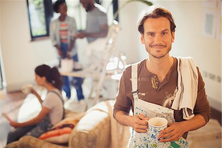 simsearch:693-03308062,k - Portrait smiling man drinking coffee and painting living room Foto de stock - Sin royalties Premium, Código: 6113-09059340